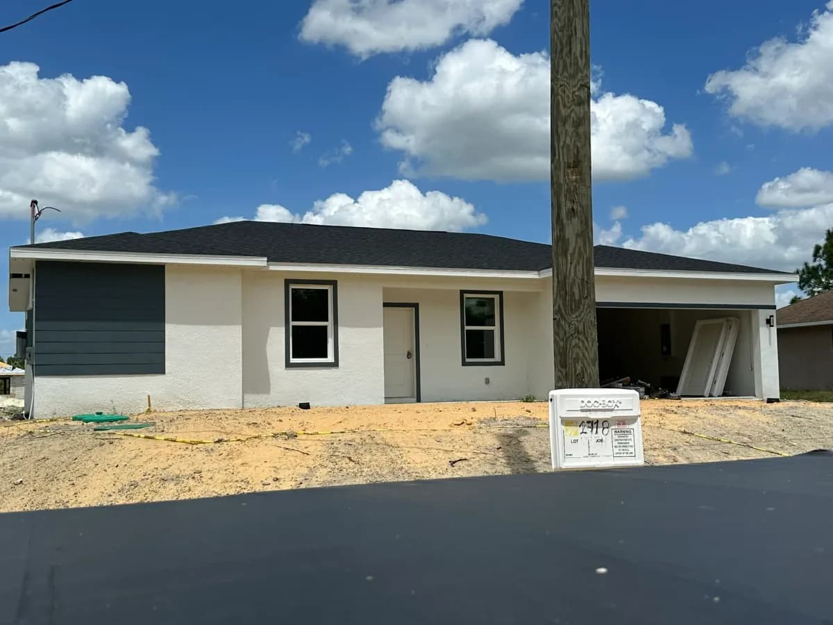 New construction soffit installation in progress - white aluminum vented soffit under blue sky